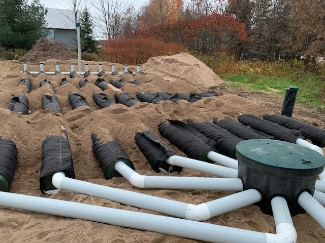 Un tas de tuyaux sont posés dans le sable.