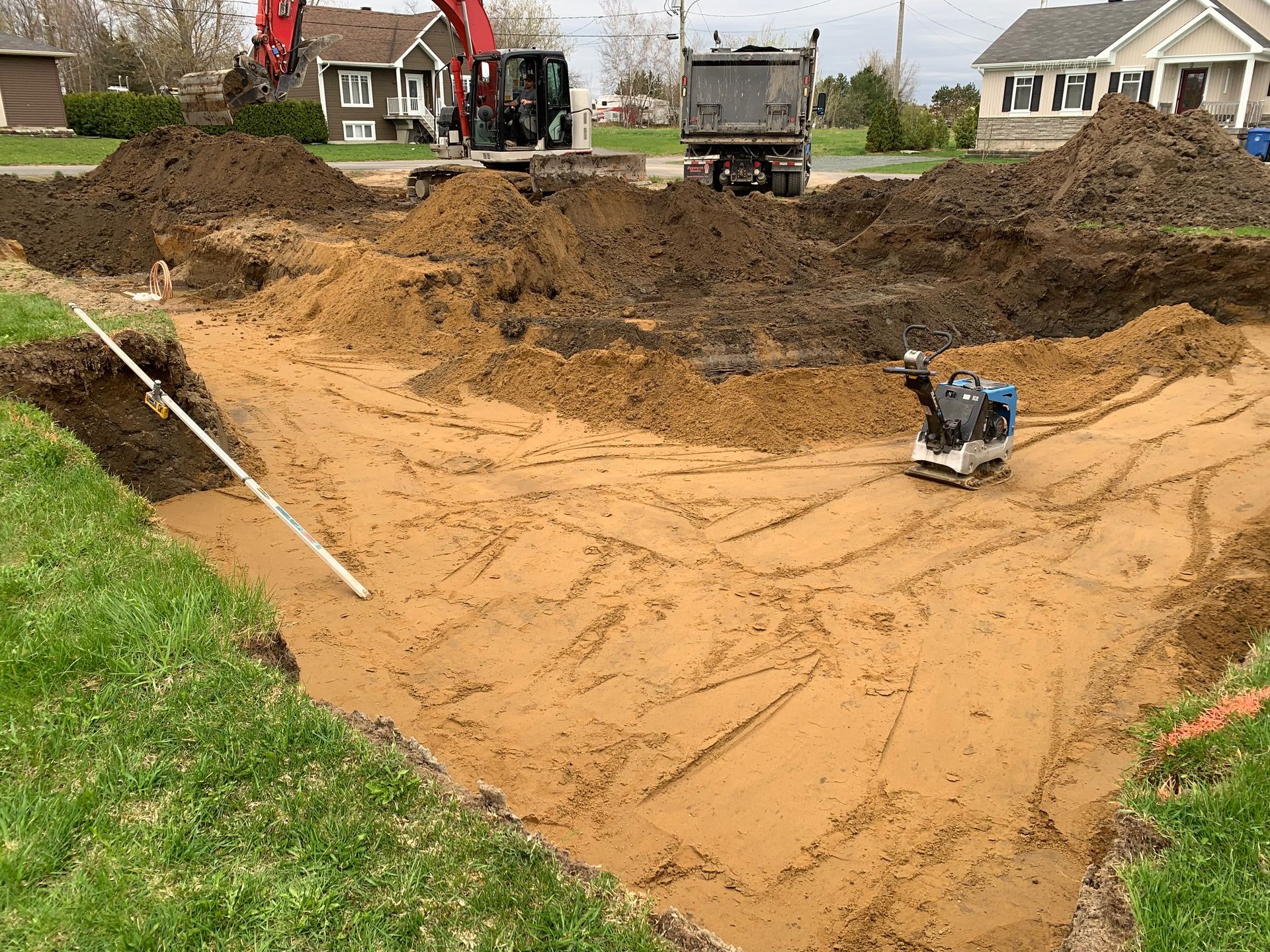 Un gros tas de terre est en train d'être chargé dans un camion à benne basculante.