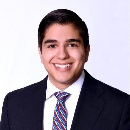 A man in a suit and tie is smiling for the camera.