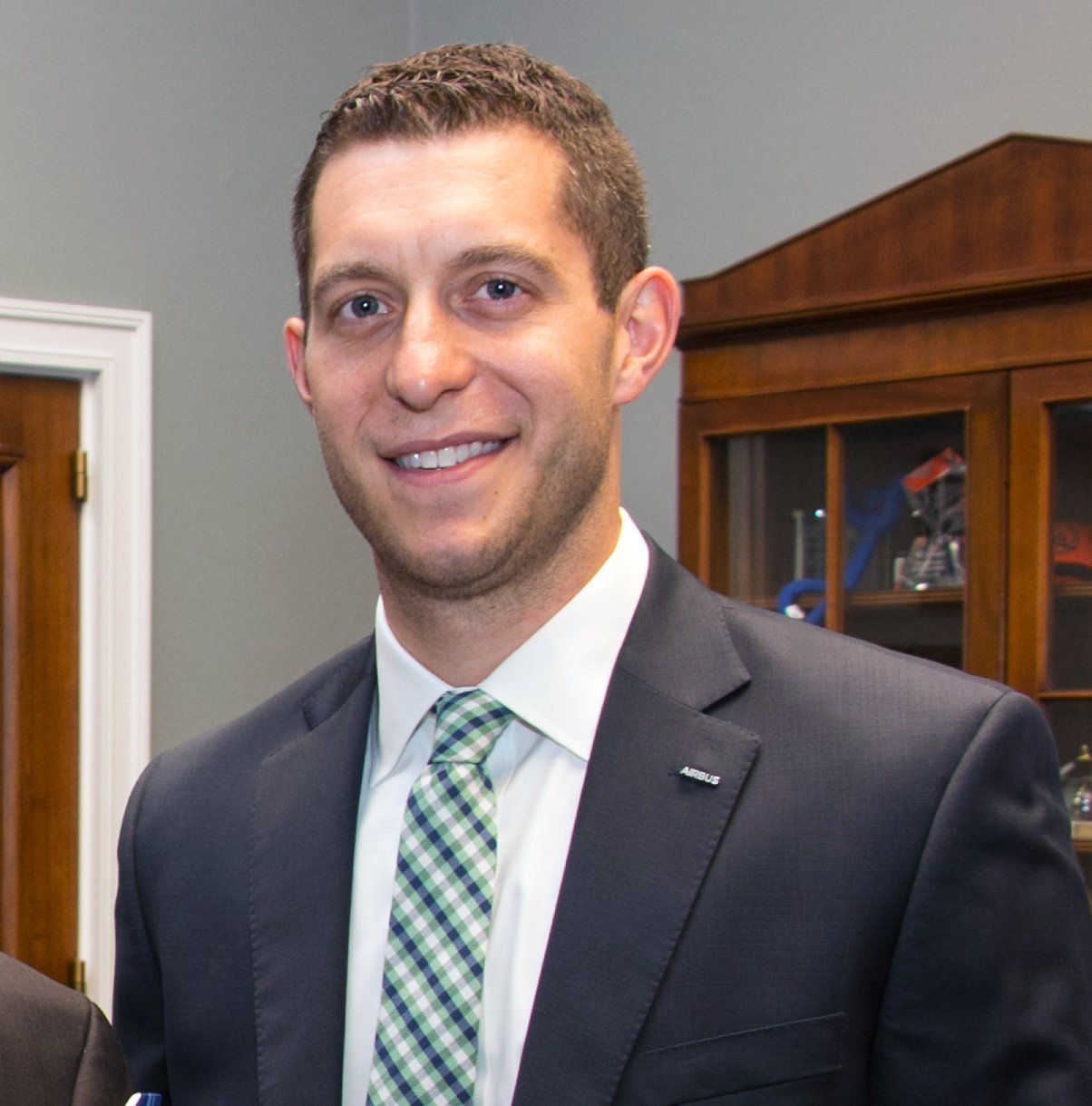 A man in a suit and tie is smiling for the camera