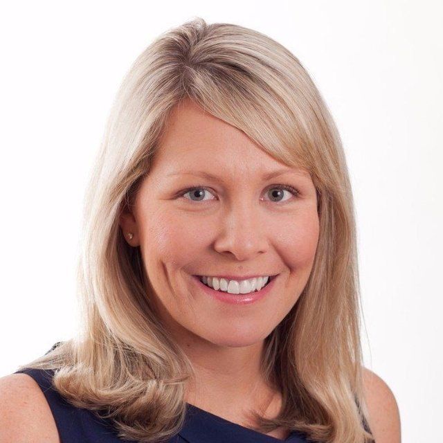 A woman with blonde hair is smiling for the camera