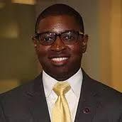 A man in a suit and tie is smiling for the camera.
