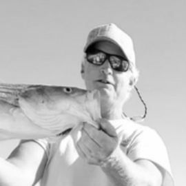 Black and white close up image of man holding a fish