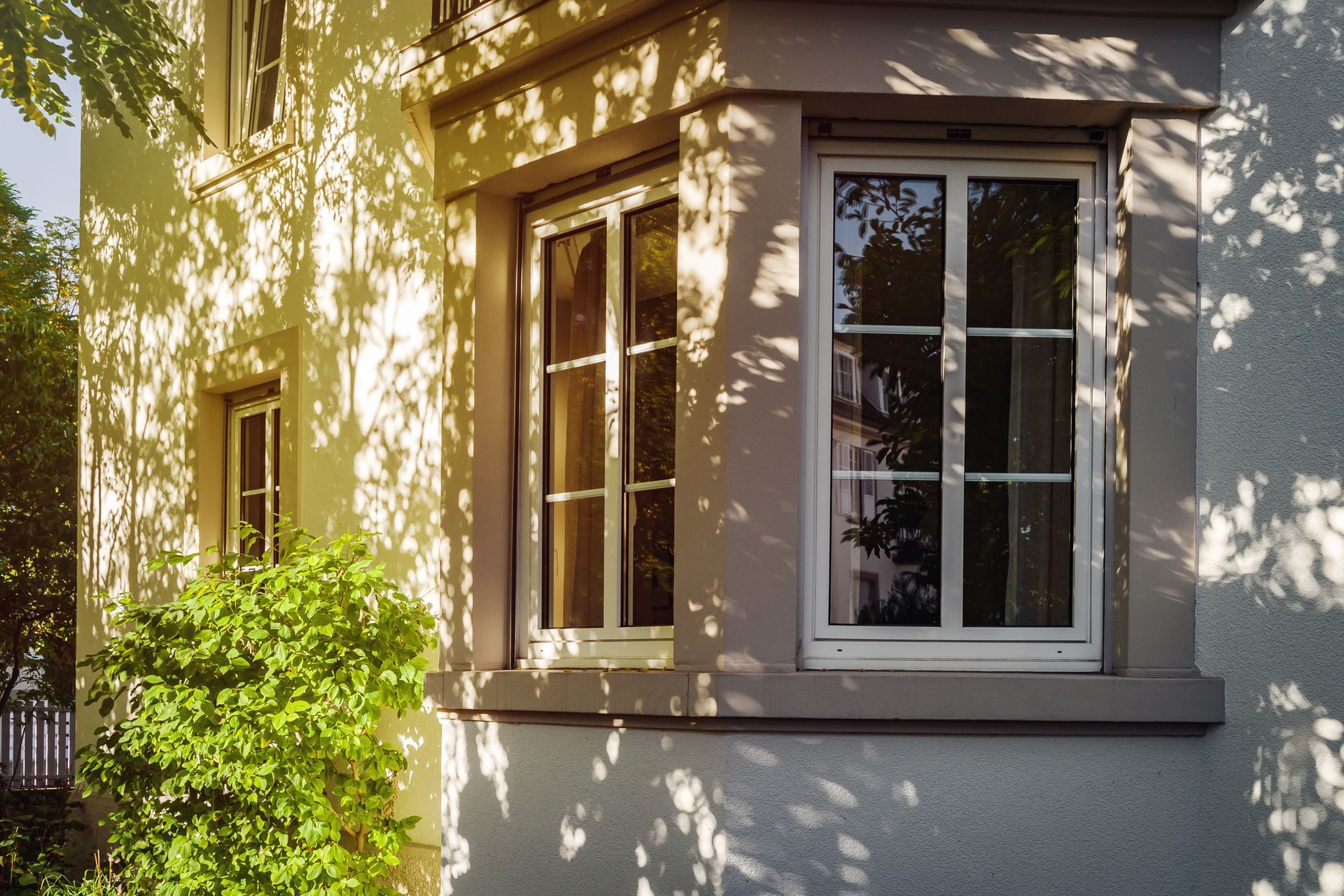 Vinyl window with a white frame on a beige house exterior.