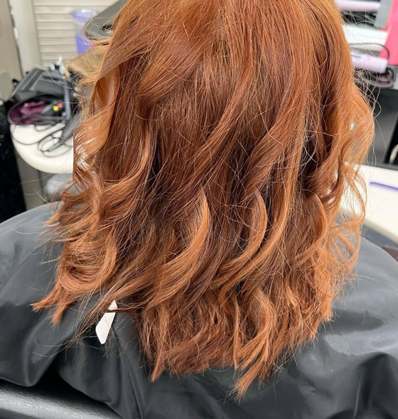 Shoulder-length, wavy auburn hair at a salon.