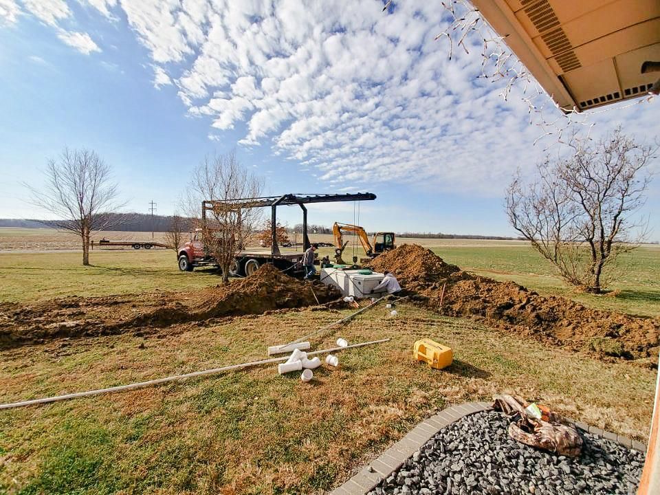 A large pile of dirt is being dug in a field.