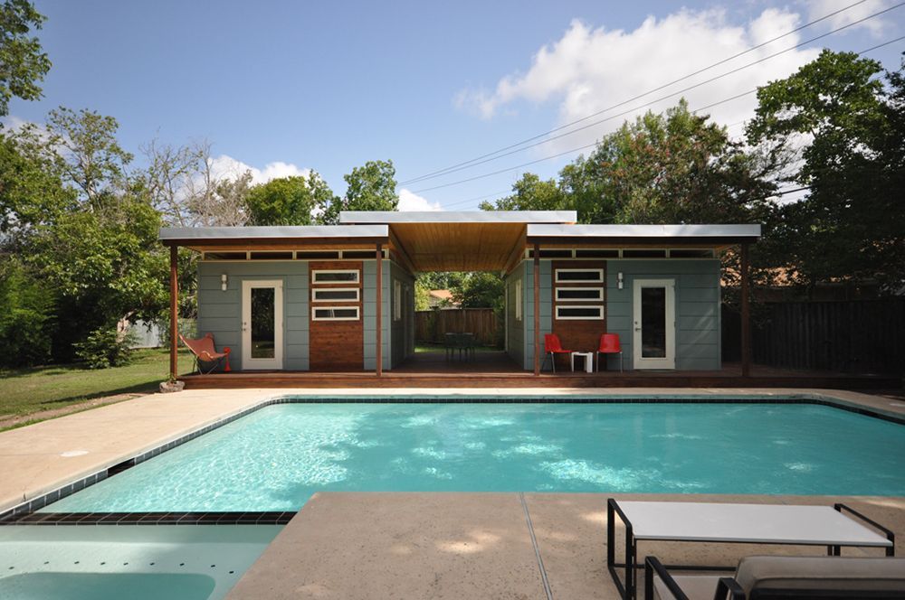 A house with a large swimming pool in front of it