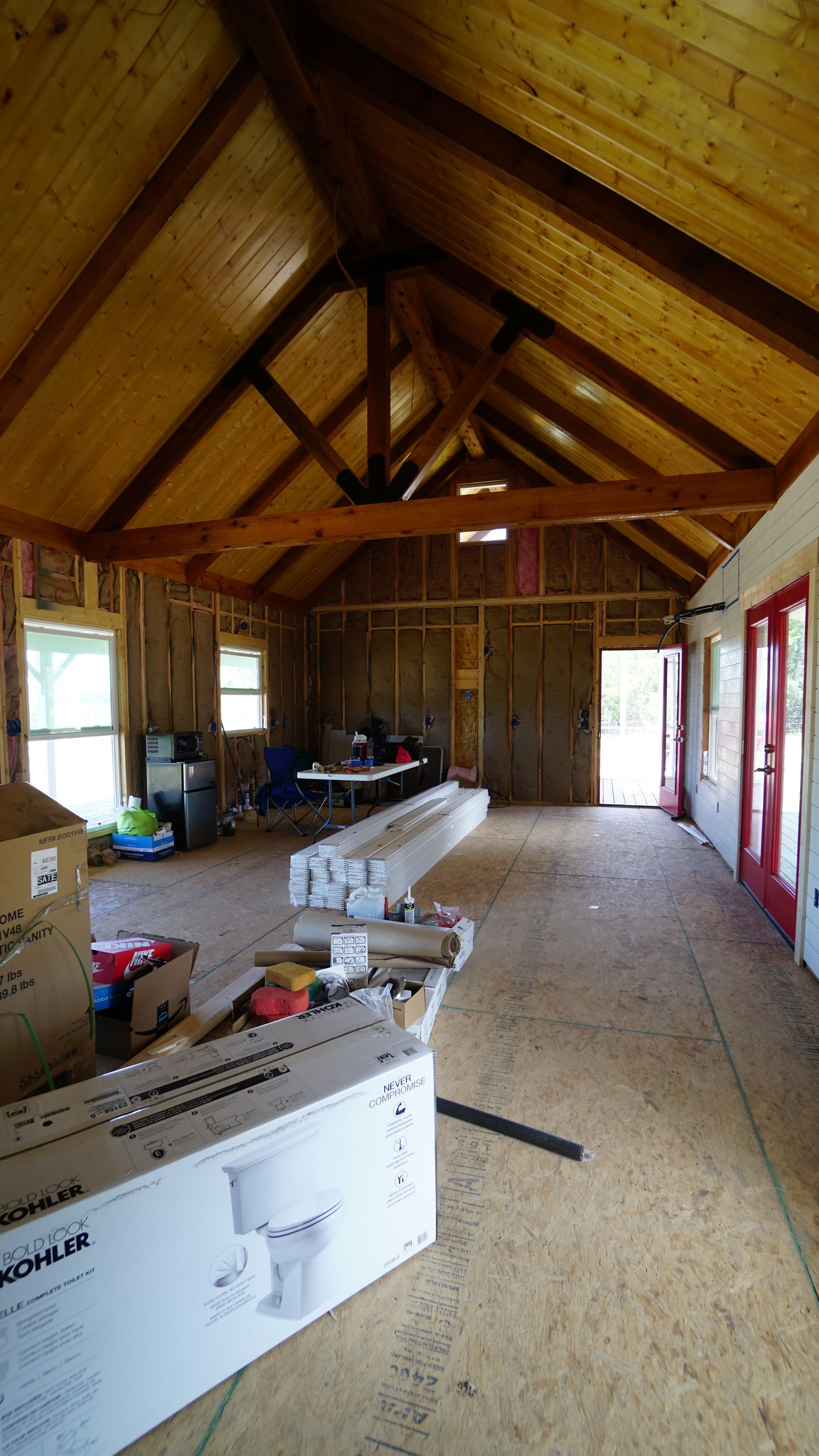 Interior of a building under construction, with wooden beams and unfinished walls.