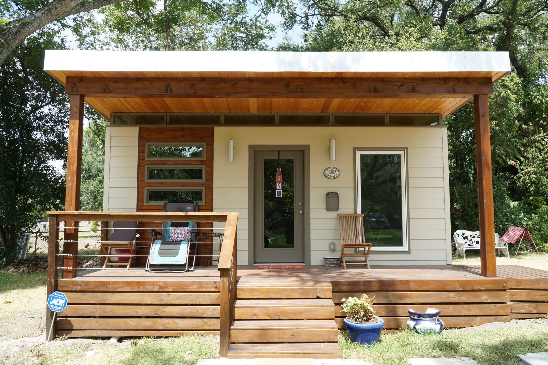 Small modern house with porch and wooden deck.