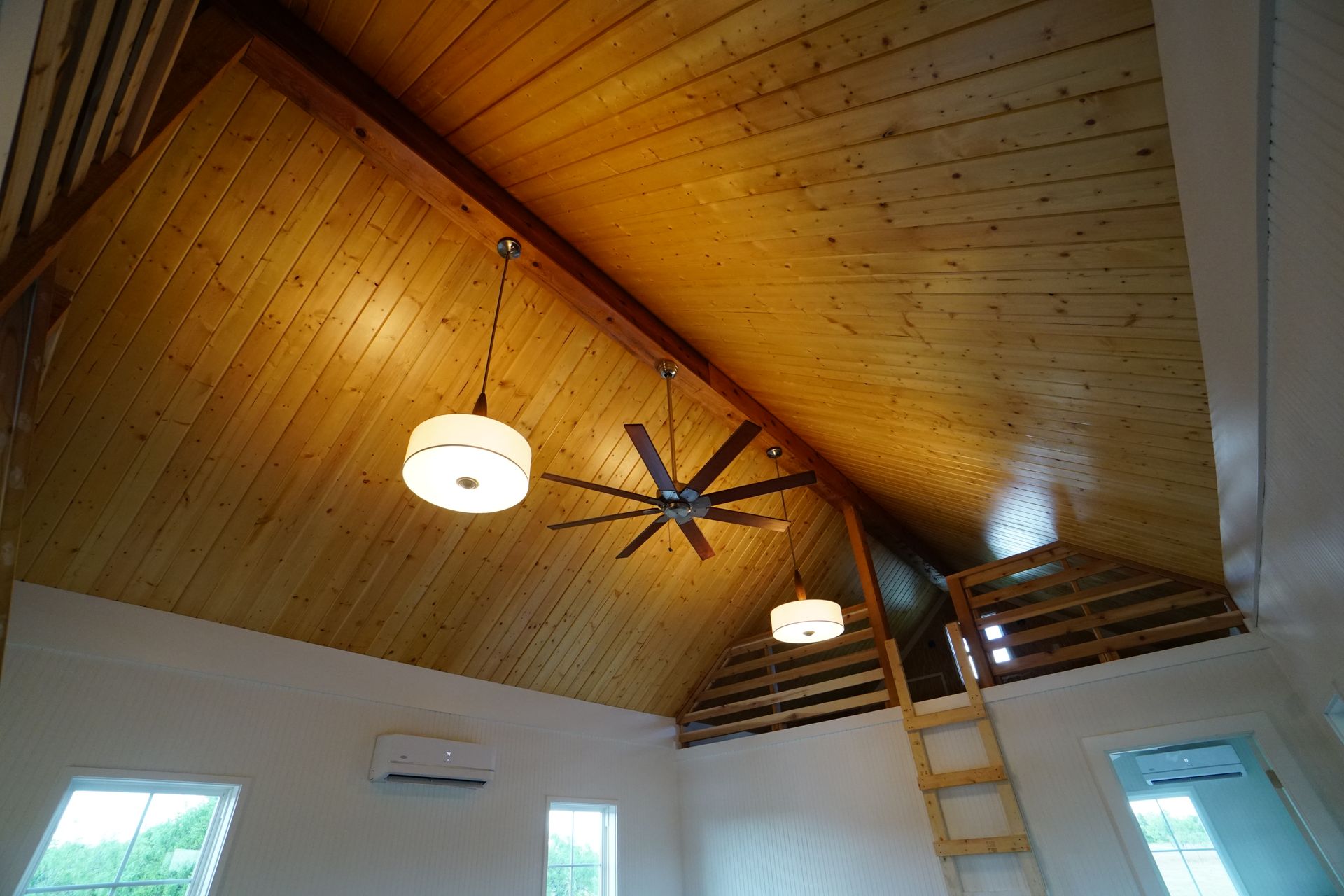 Wooden vaulted ceiling with lights and a ceiling fan. Ladder to loft.