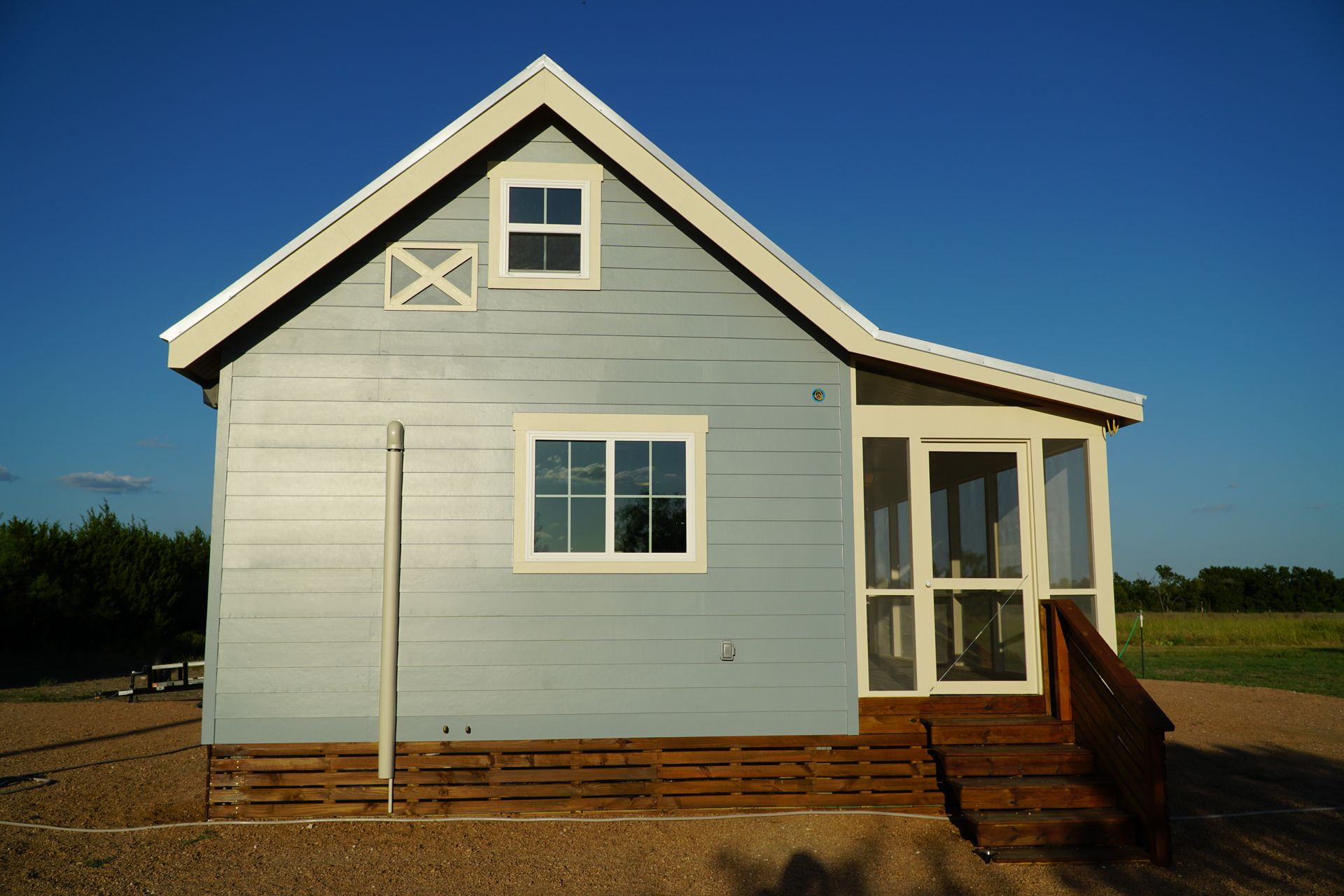 Small light blue house with white trim and a small porch.