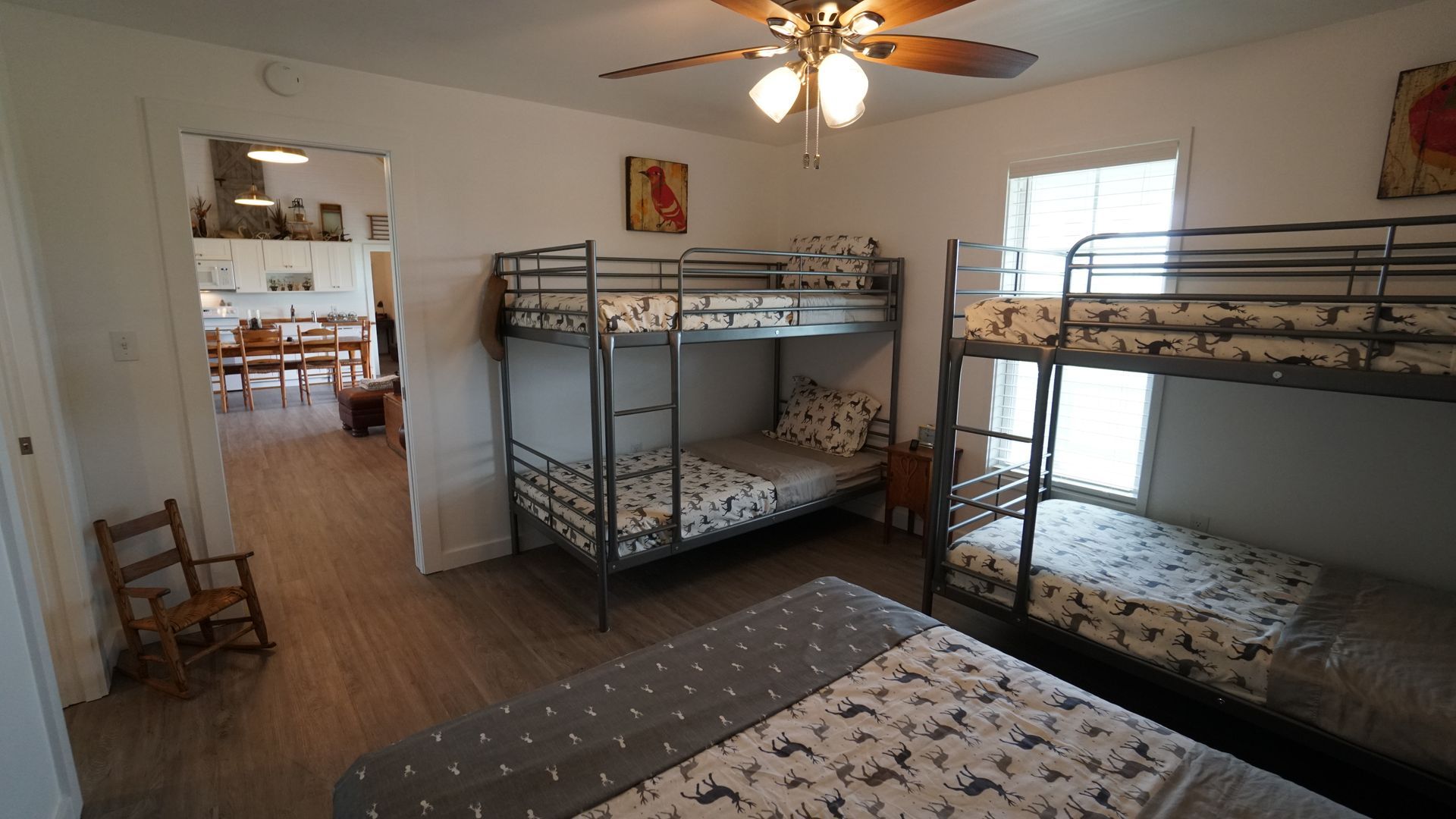 Bedroom with three bunk beds and one double bed, leading to a kitchen.
