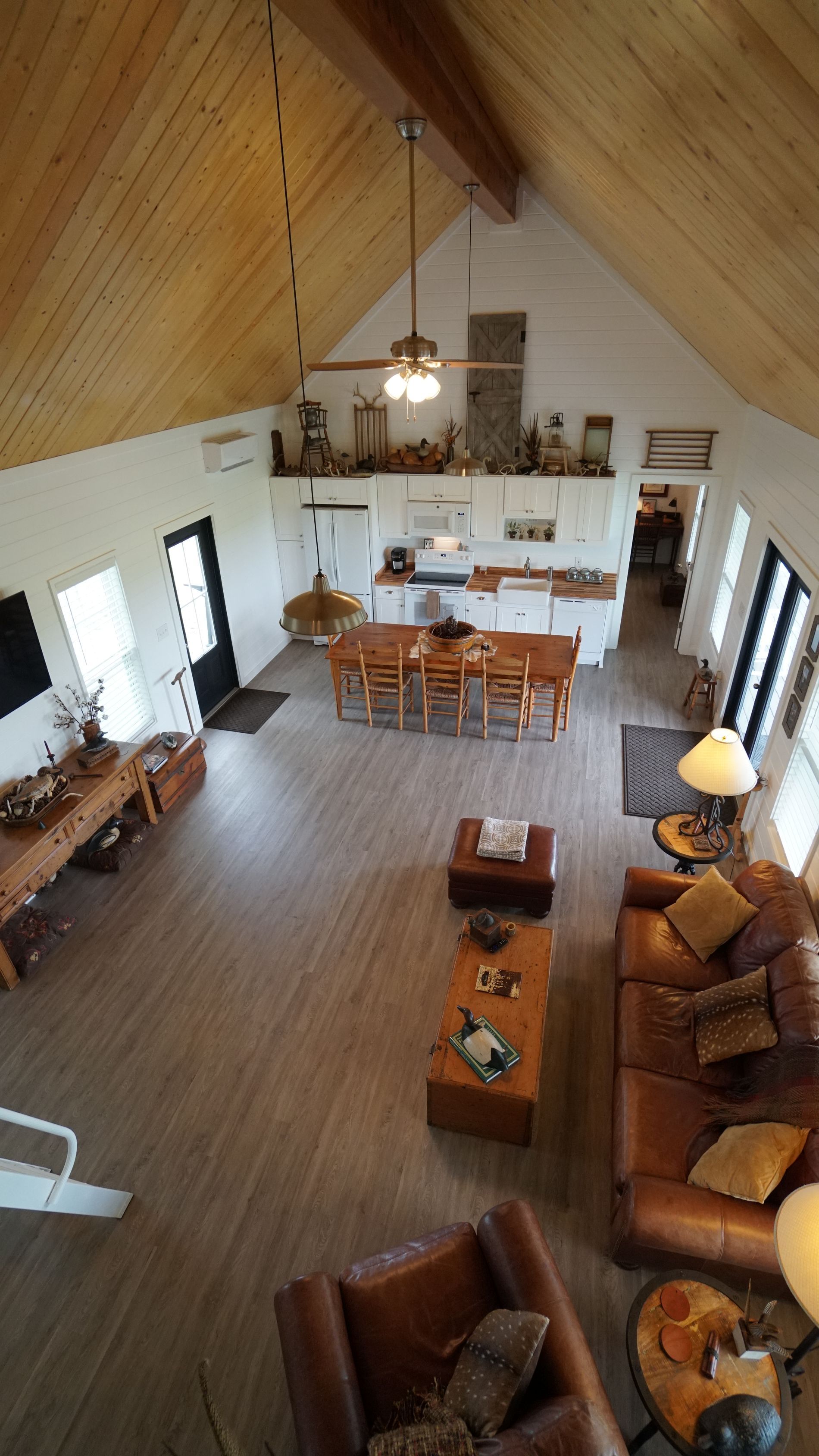 High-angle shot of a bright, open-plan living area with a kitchen, dining table, and seating area.