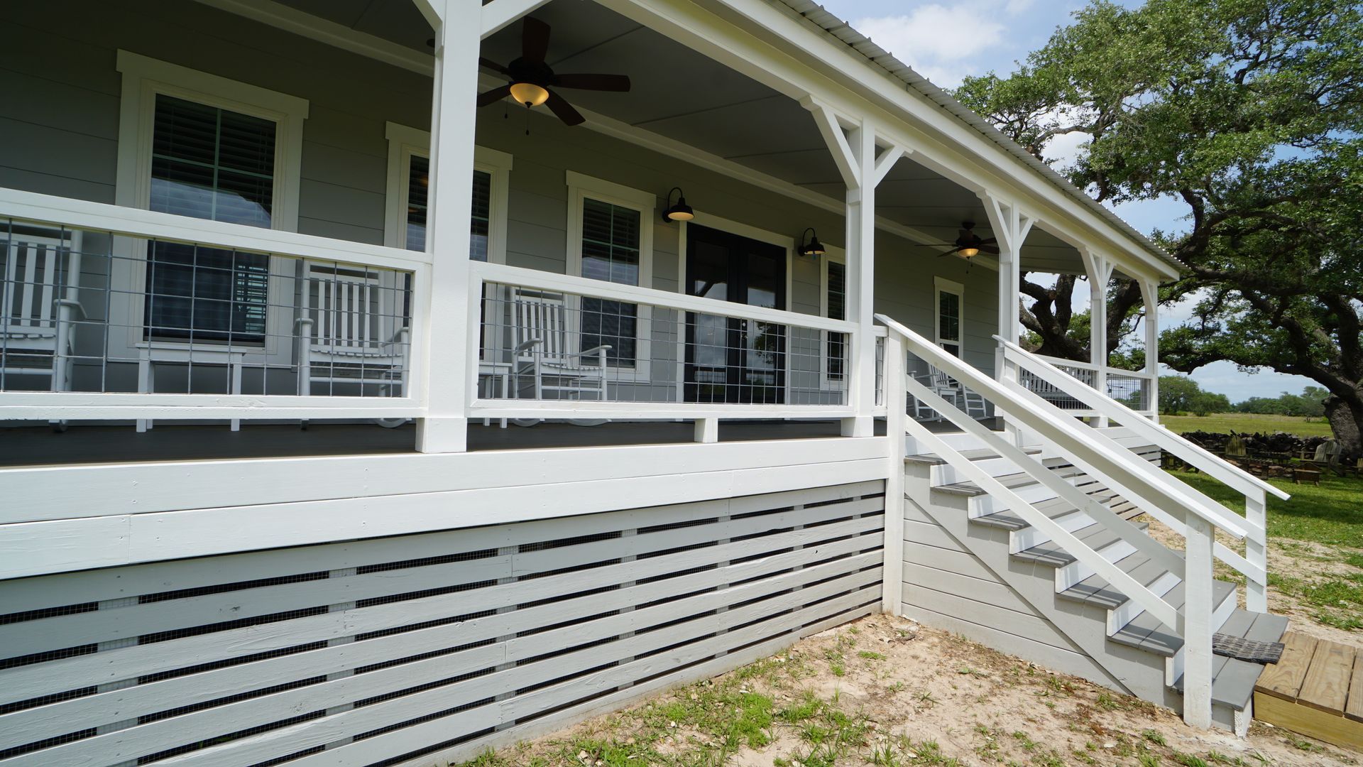 Light gray house with a white porch and stairs.