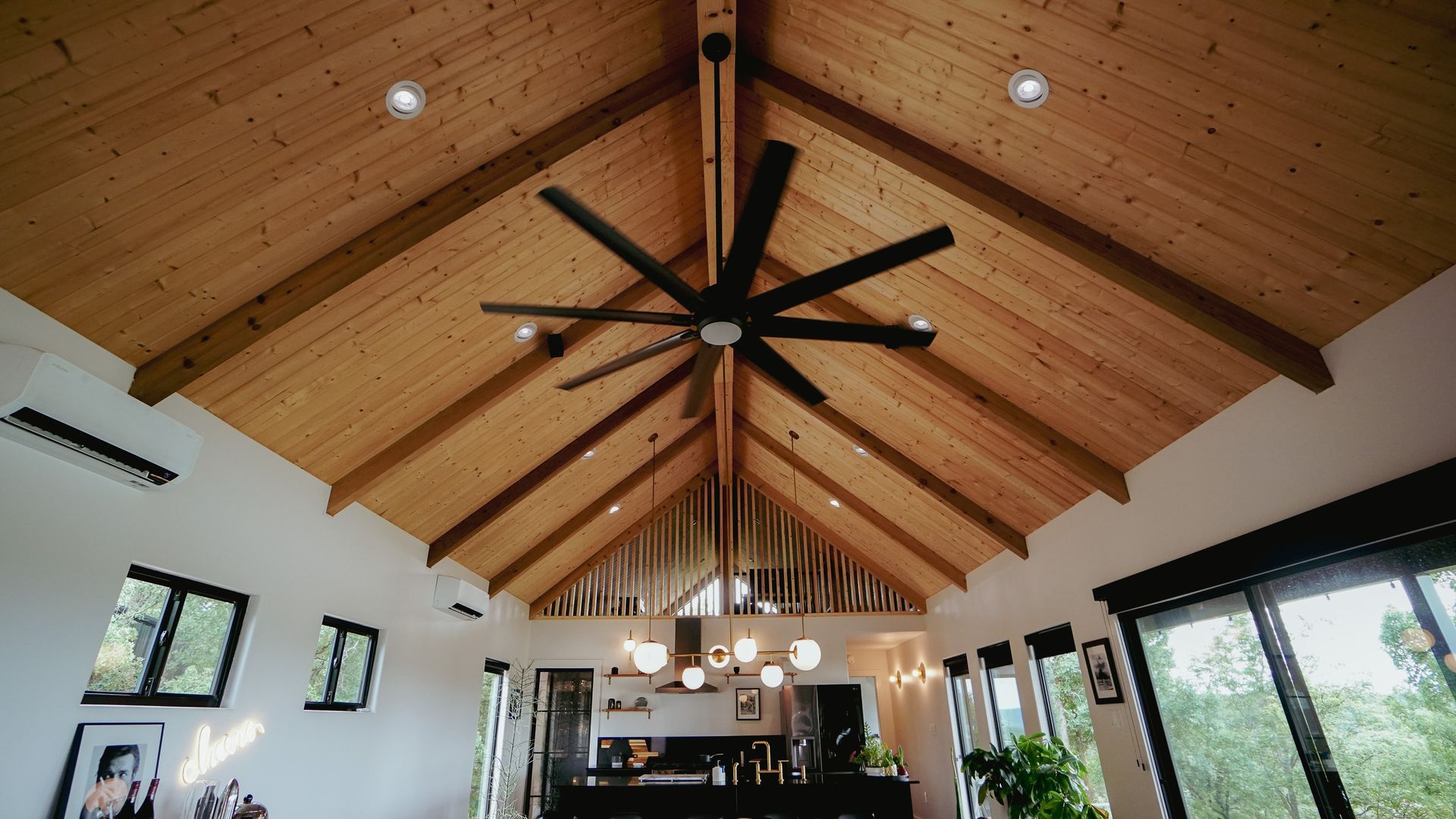 Wooden vaulted ceiling with a large ceiling fan and recessed lighting; interior view.
