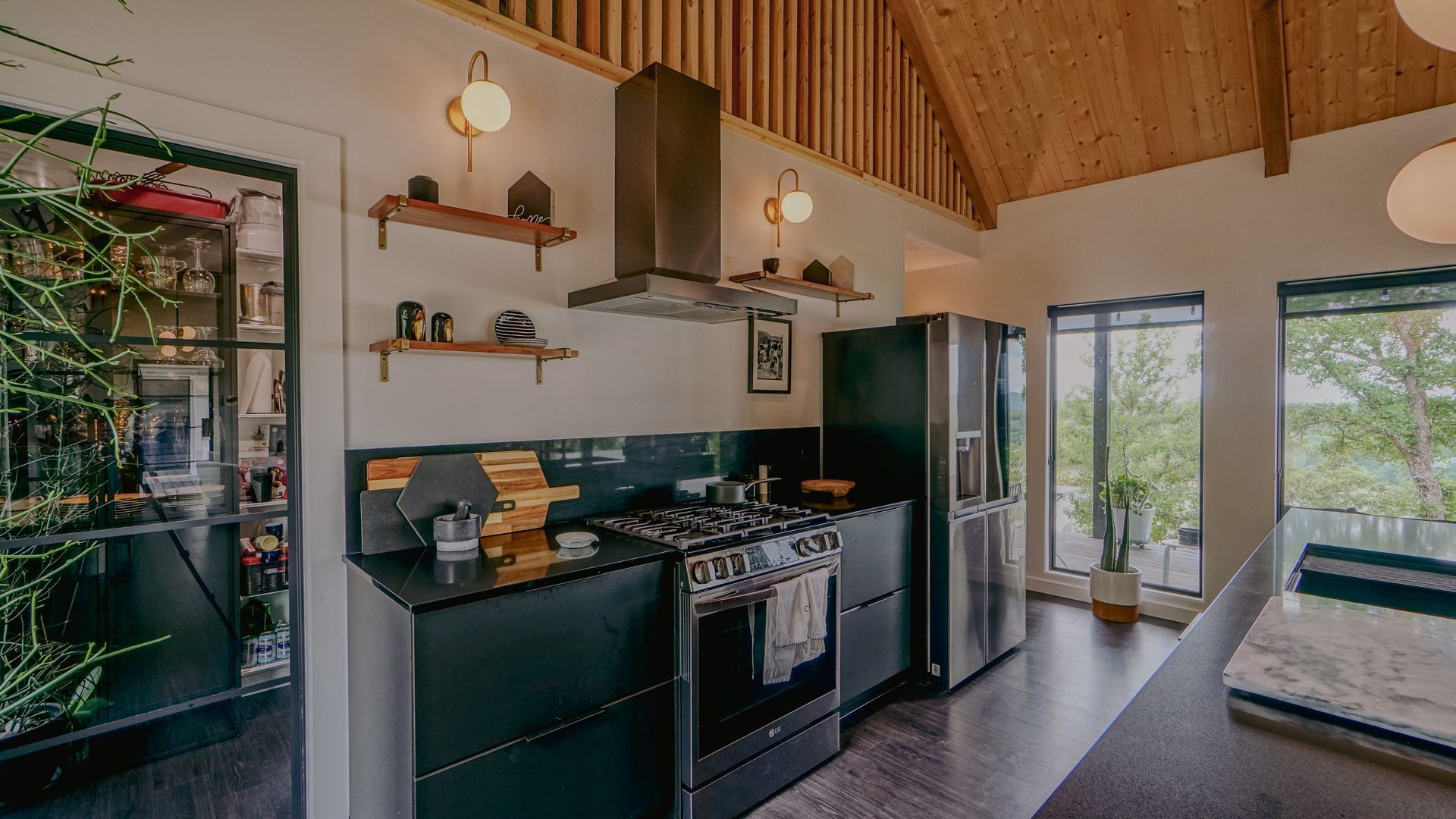 Modern kitchen with dark cabinets, stainless steel appliances, and wooden accents.