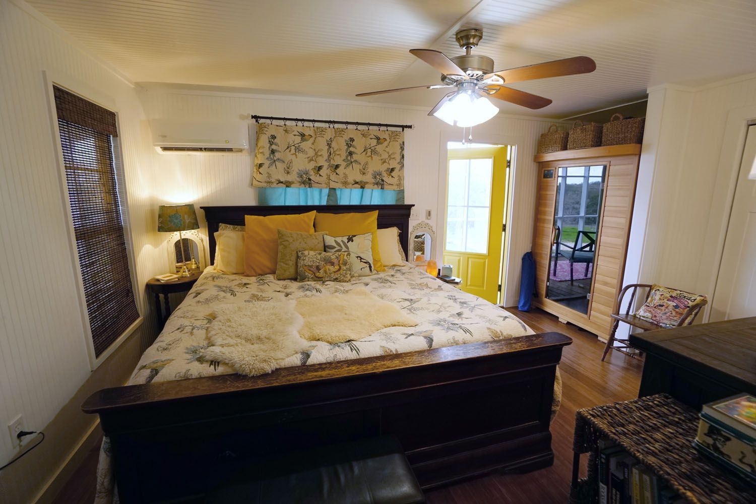 Bedroom with a large bed, yellow accents, and a door leading to a balcony.