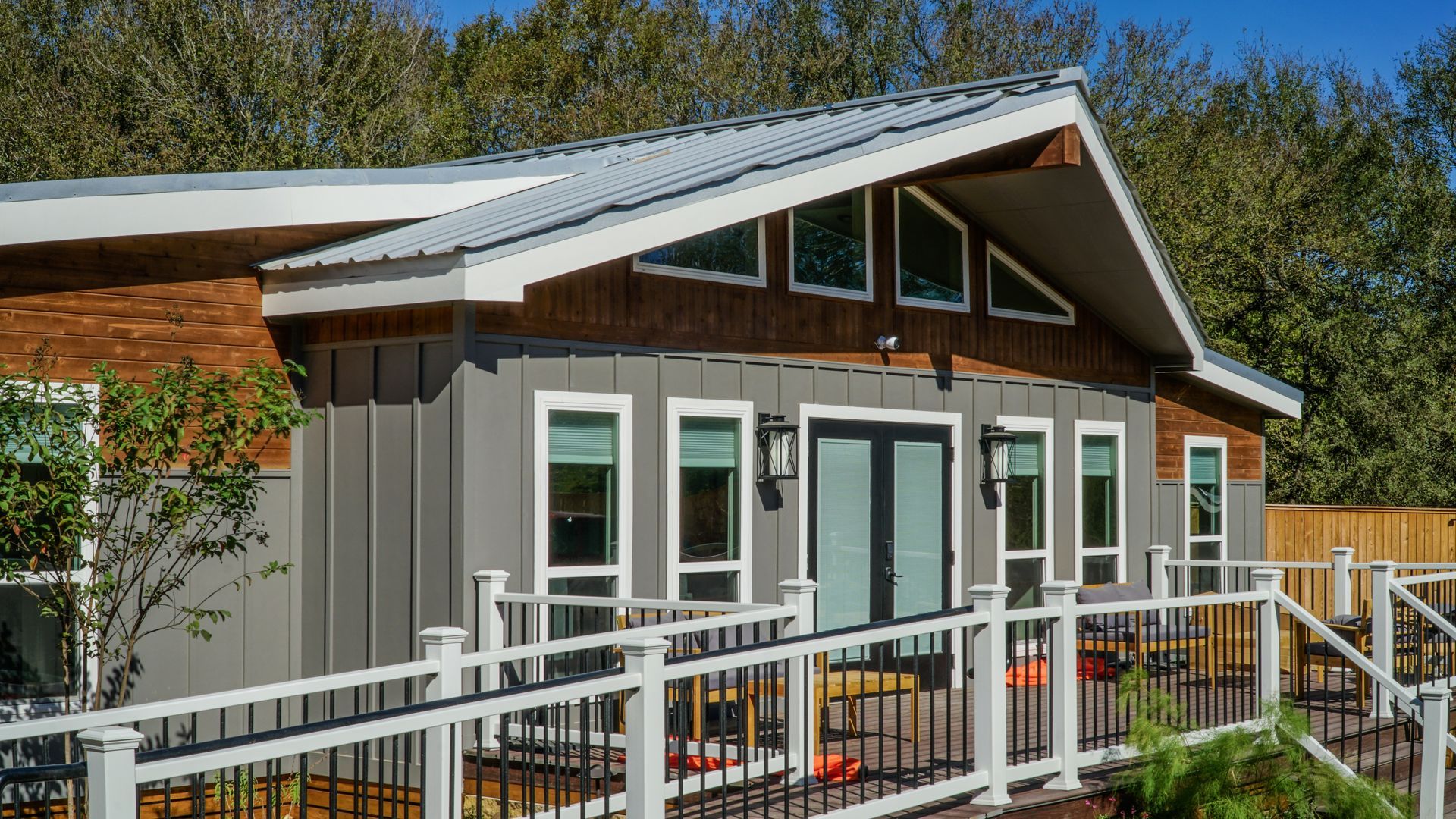 Grey and brown modern building with ramp access and metal roof.