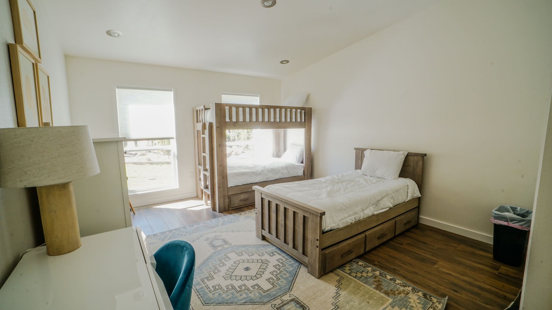 Bedroom with bunk beds, a single bed, desk, and area rug.