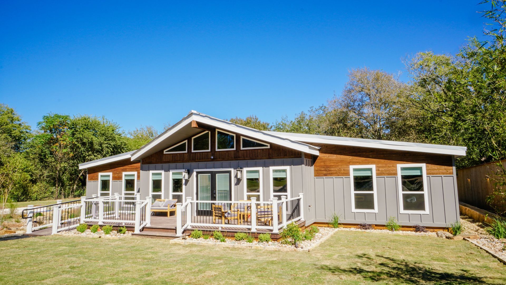 Gray and brown house with a deck on a sunny day.