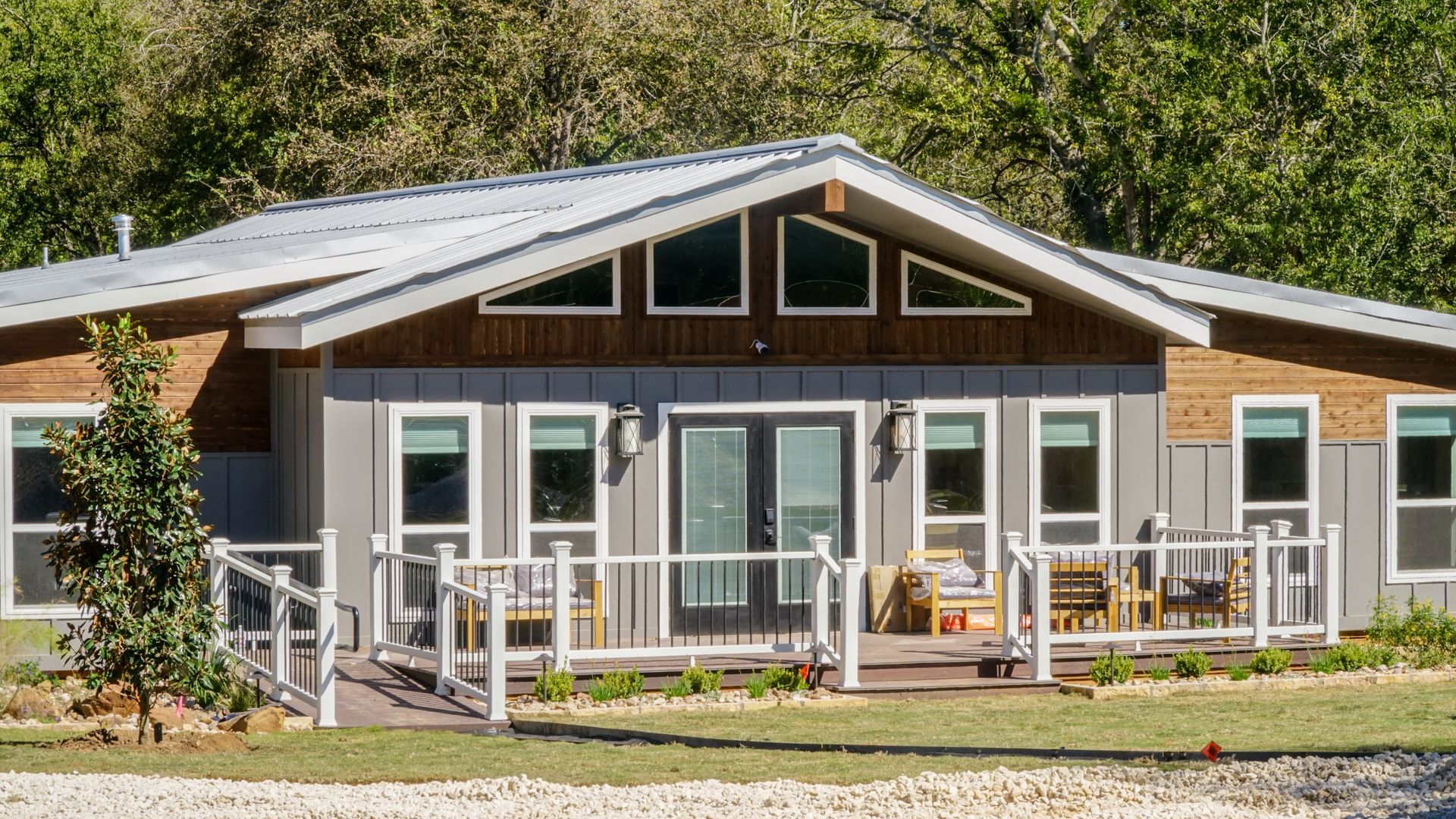 Modern house with gray siding, wooden accents, and a deck.
