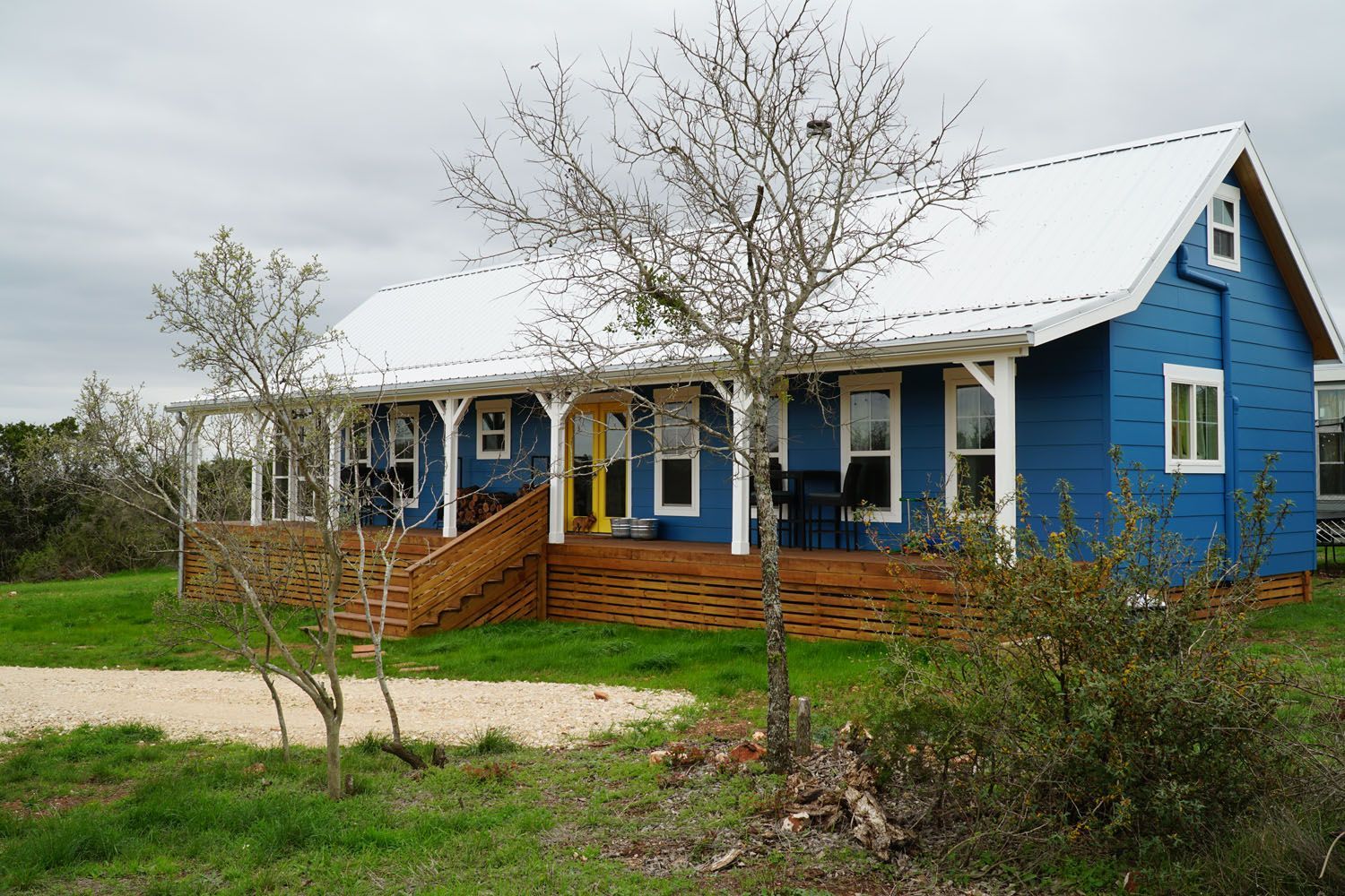 A blue house with a white roof and a porch