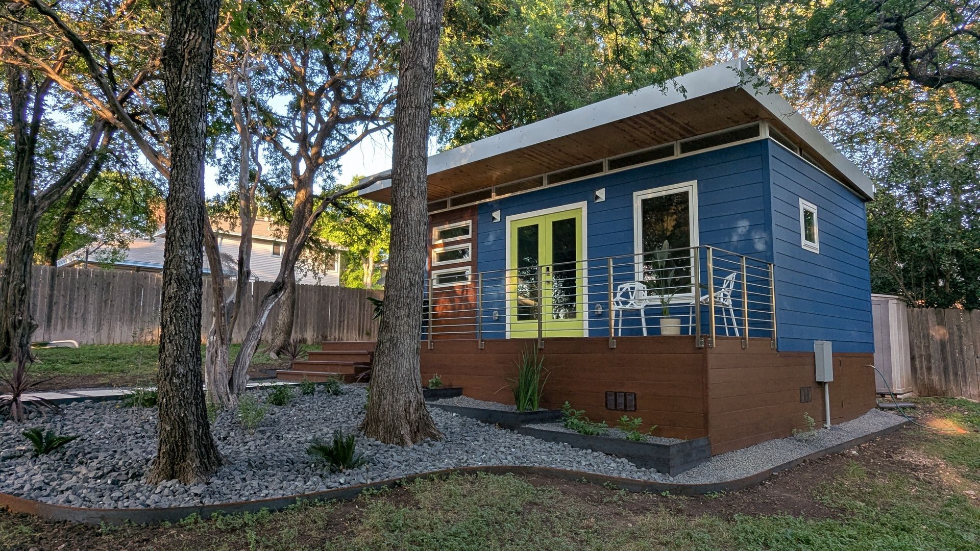 Blue and brown bungalow with yellow doors, white trim, and a small porch.