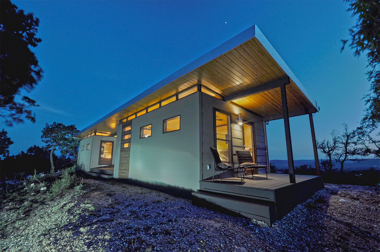 A small house with a porch is lit up at night.