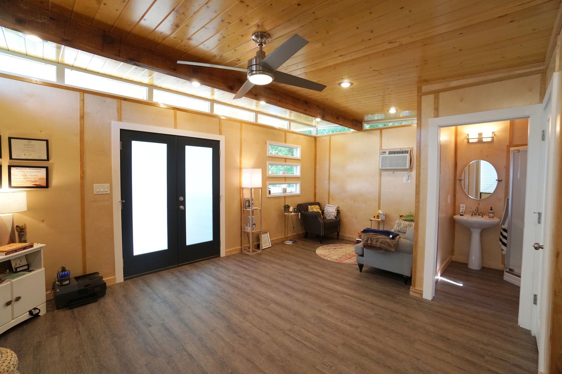 Interior of a room with wood paneling, French doors, and a bathroom visible.
