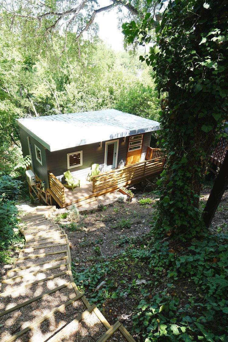 A small house is sitting in the middle of a forest.