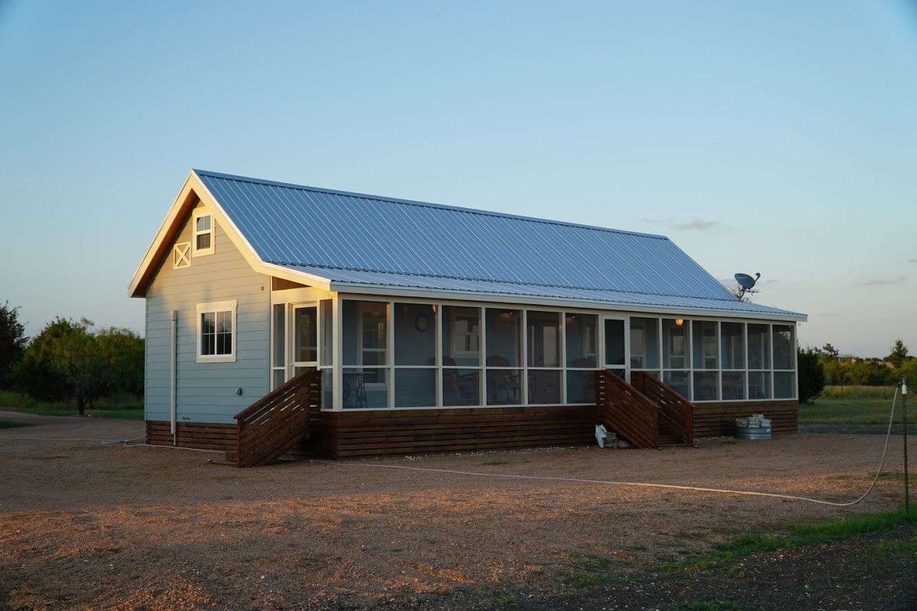 A small house with a screened in porch and stairs