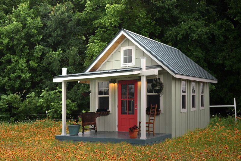 A small house with a porch and a red door