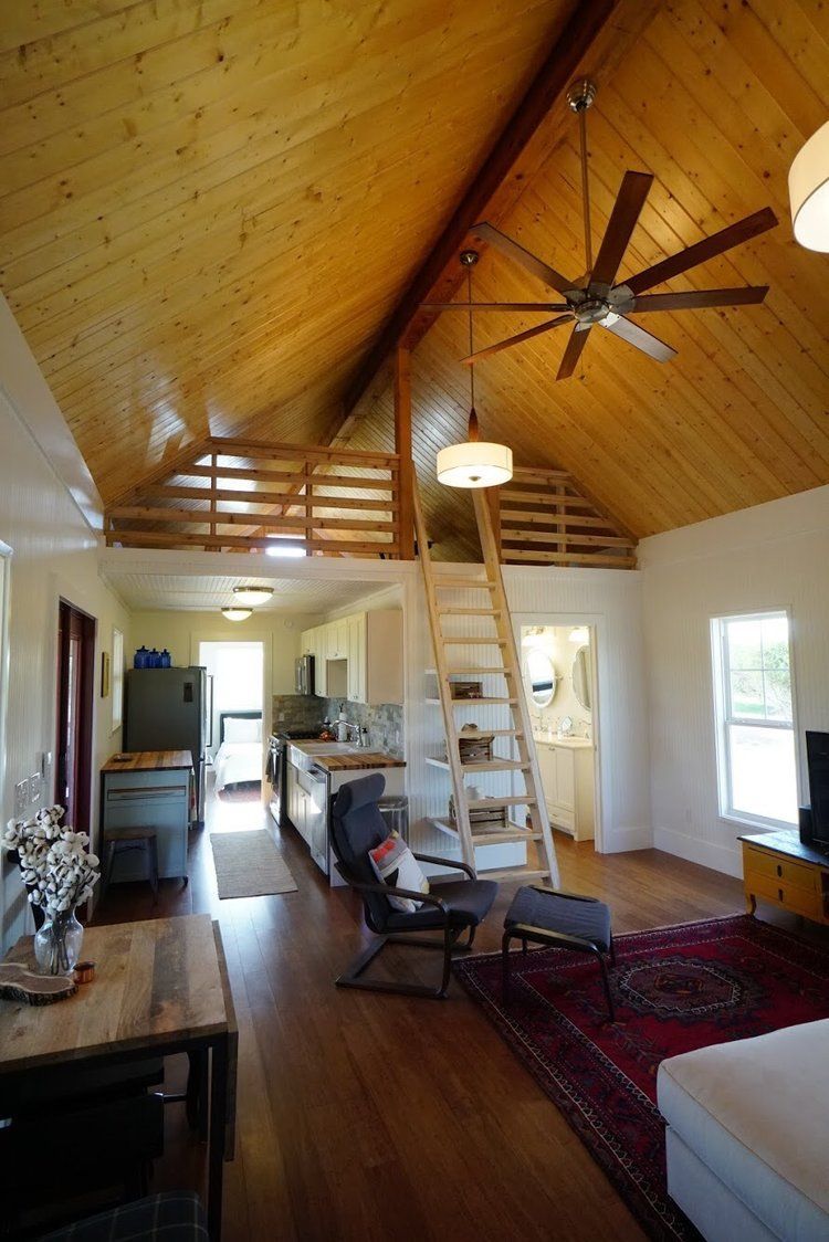 A living room with a vaulted ceiling and a staircase leading to the second floor.