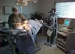 A surgeon is operating on a patient in an operating room.