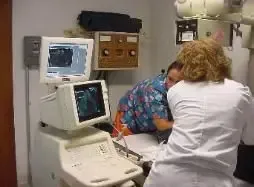 A doctor is examining a patient in a hospital room.