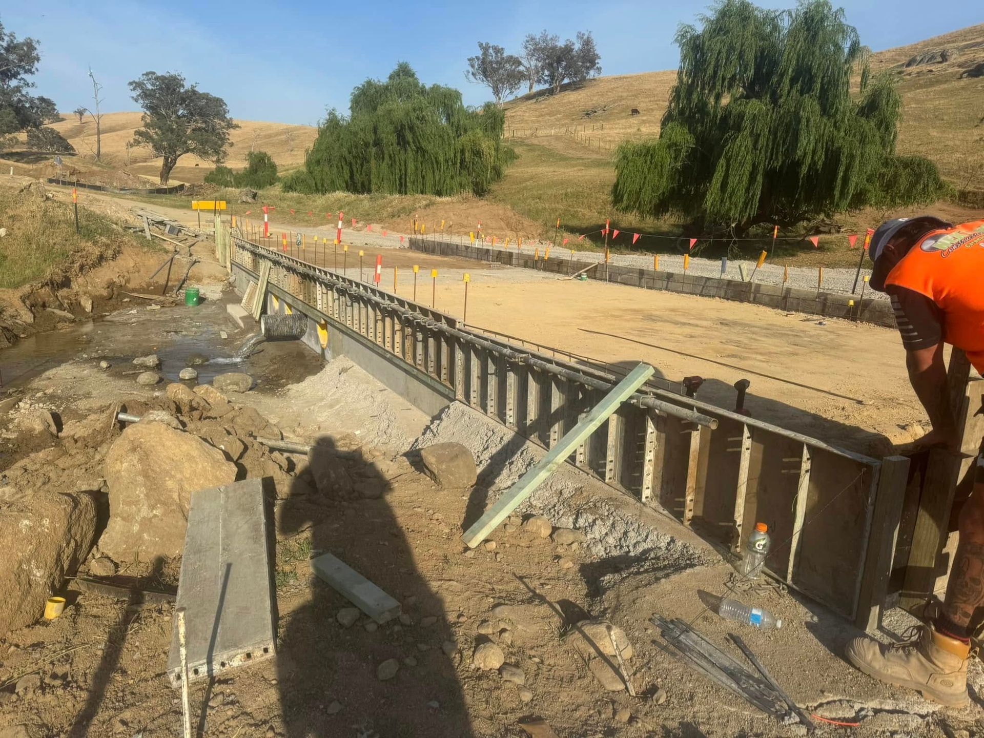 A Man is Laying Concrete on the Ground With a Trowel — Next Level Construction Contractors in Gundagai, NSW