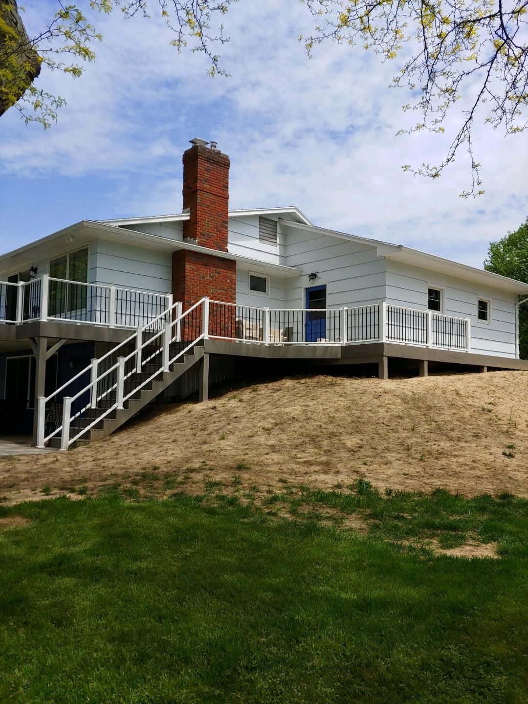 A white house with a large deck and stairs