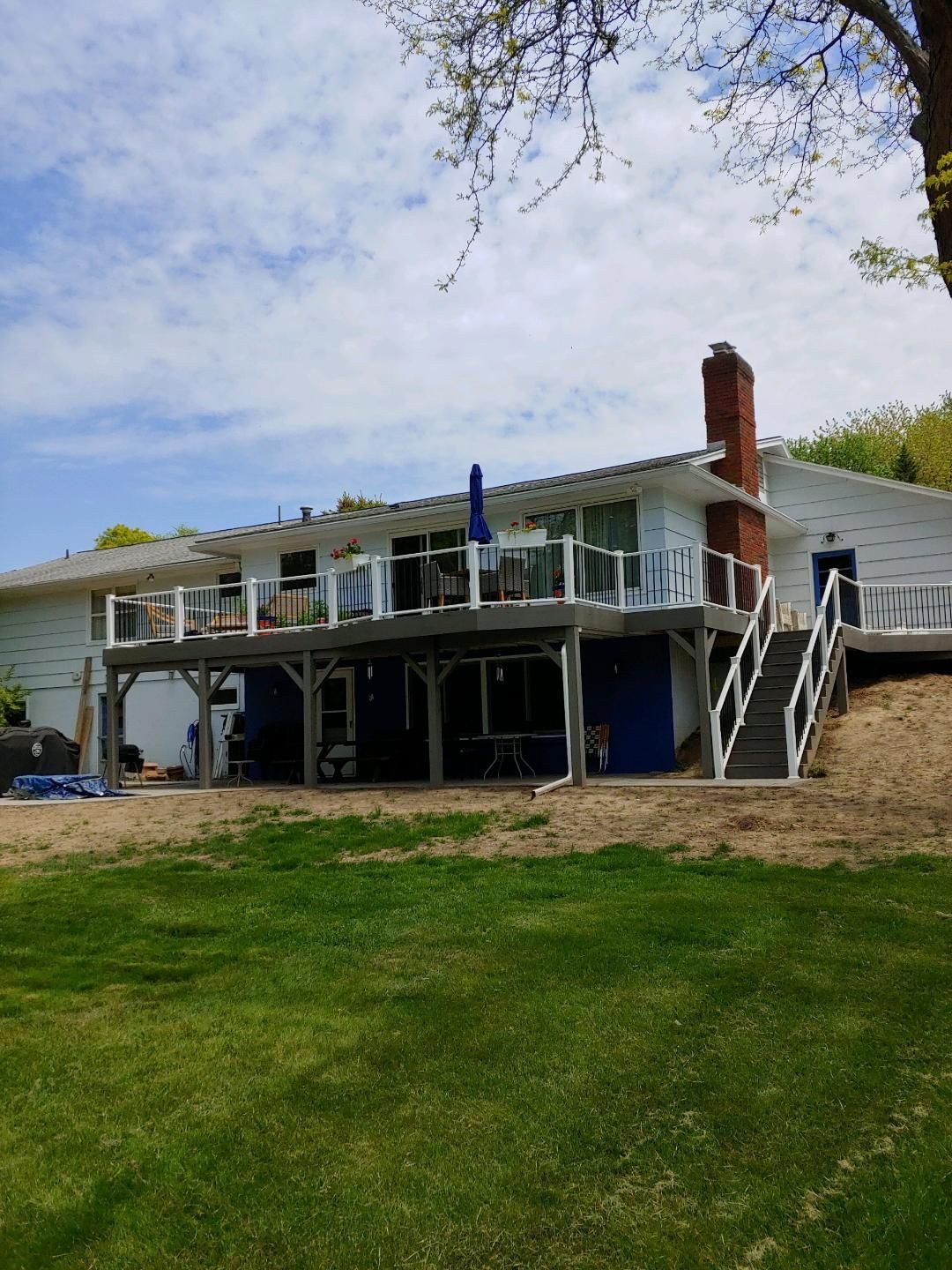 A large white house with a large deck and stairs