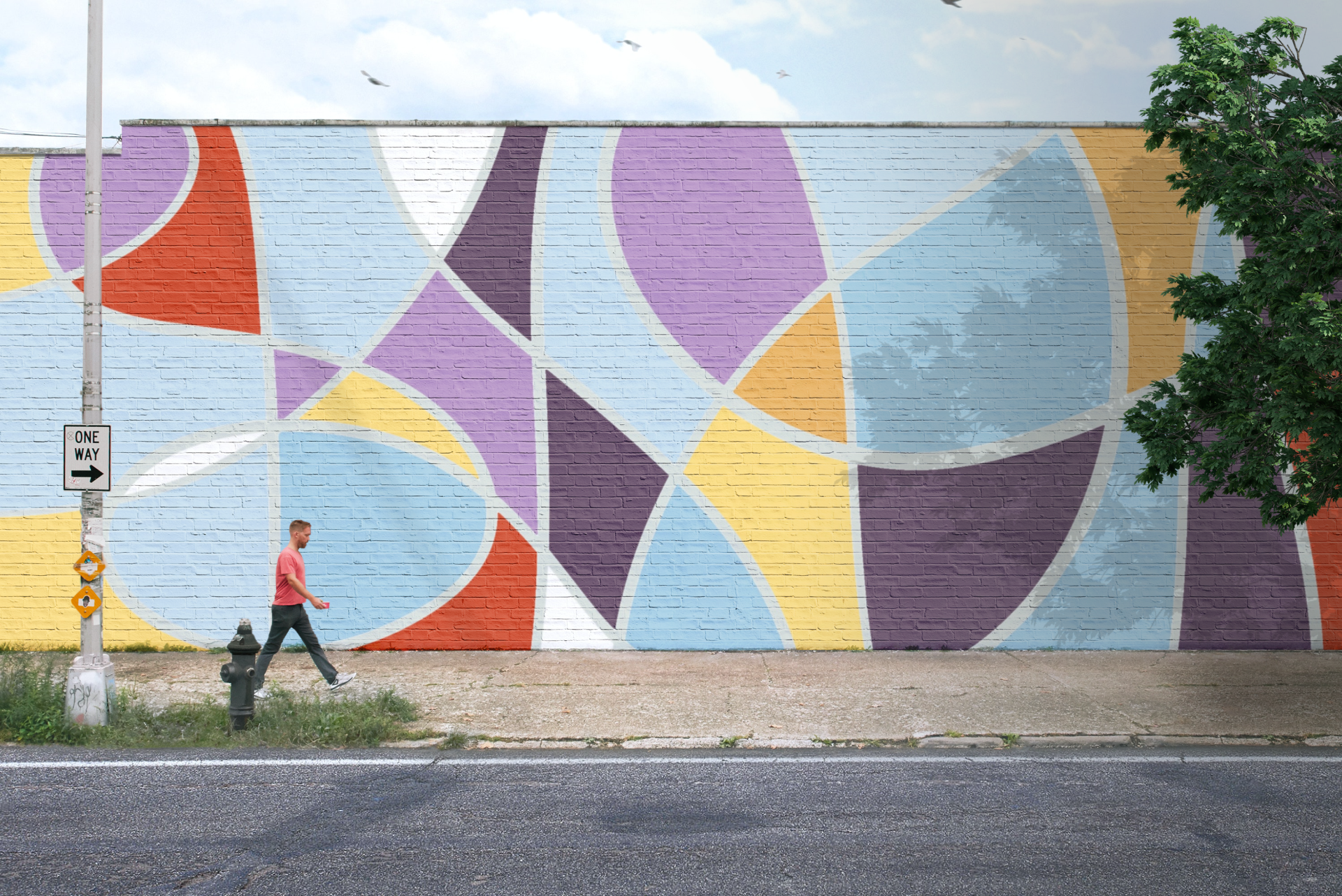 mockup of MARGO studio mural on brick wall with man walking on sidewalk in foreground