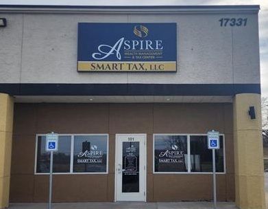 Exterior of Aspire Smart Tax LLC, beige building, sign with company logo, accessible parking.