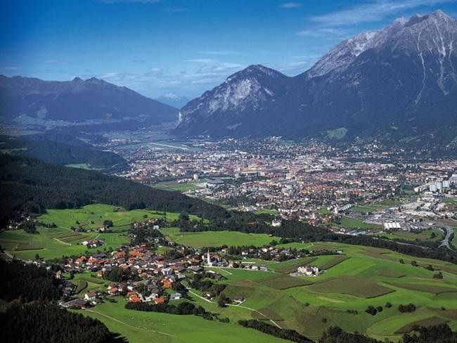 Eine Stadt mitten in einem Tal mit Bergen im Hintergrund