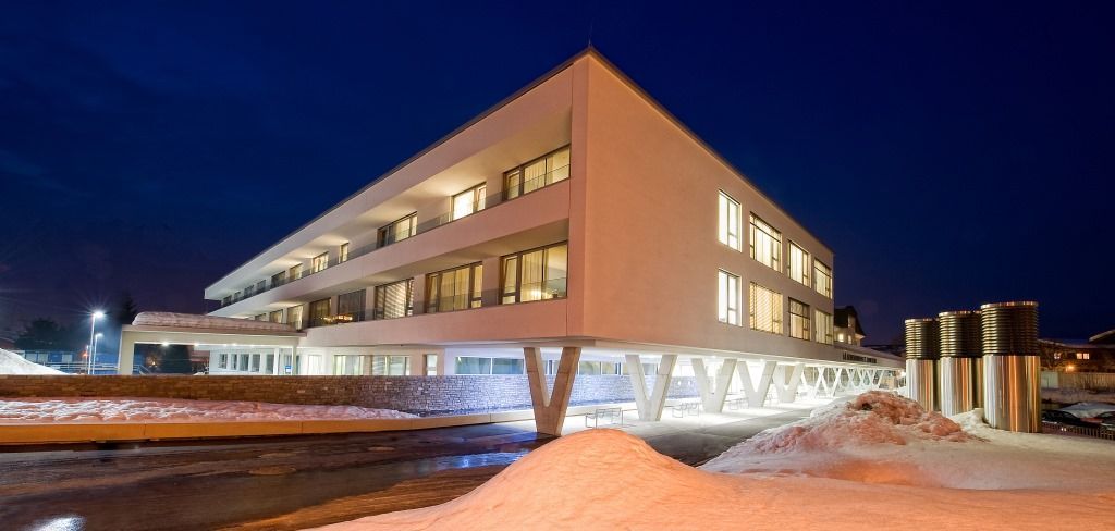 Ein großes weißes Gebäude mit vielen Fenstern ist nachts beleuchtet