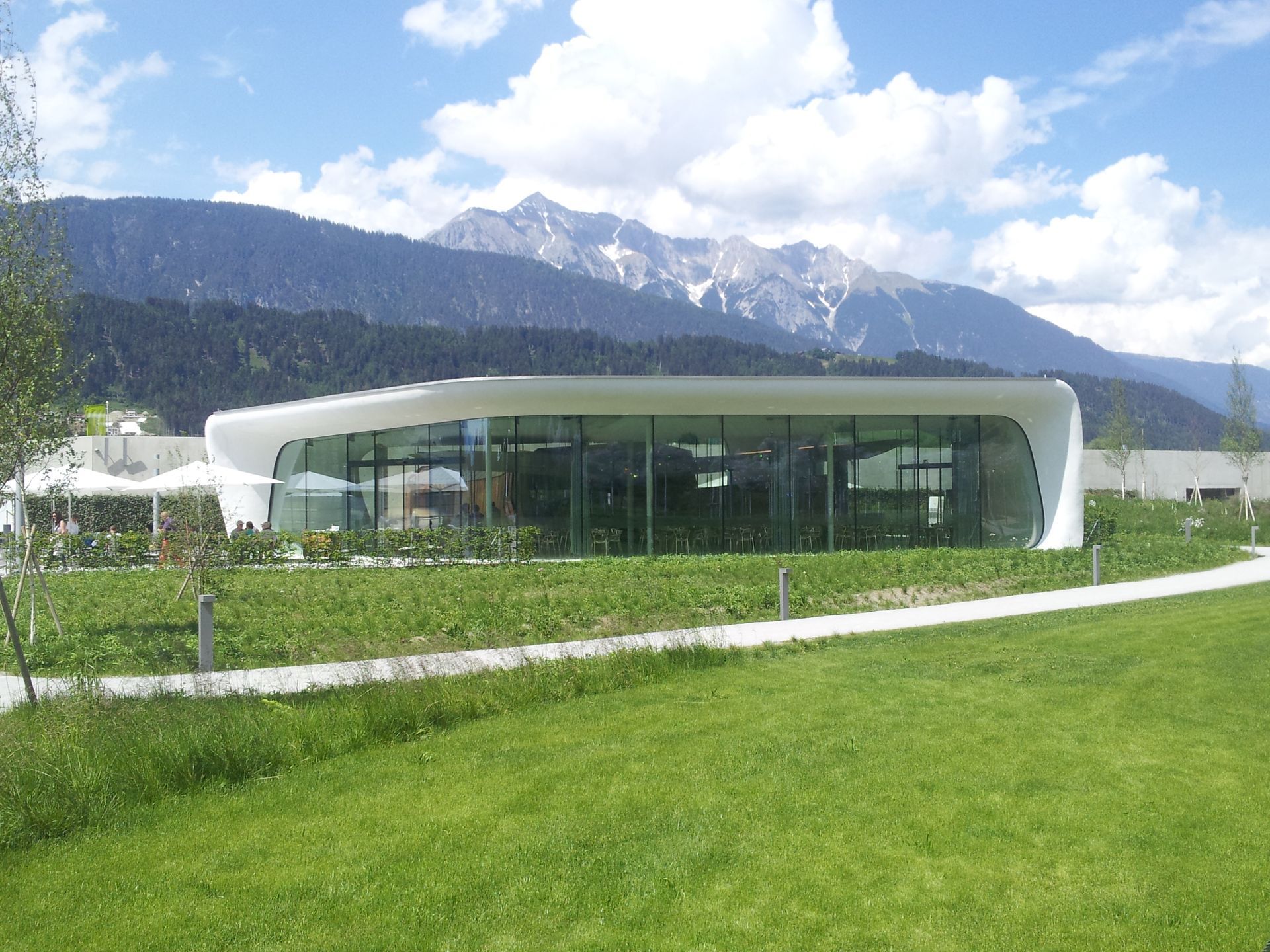 Ein großes Gebäude mit vielen Fenstern und Bergen im Hintergrund