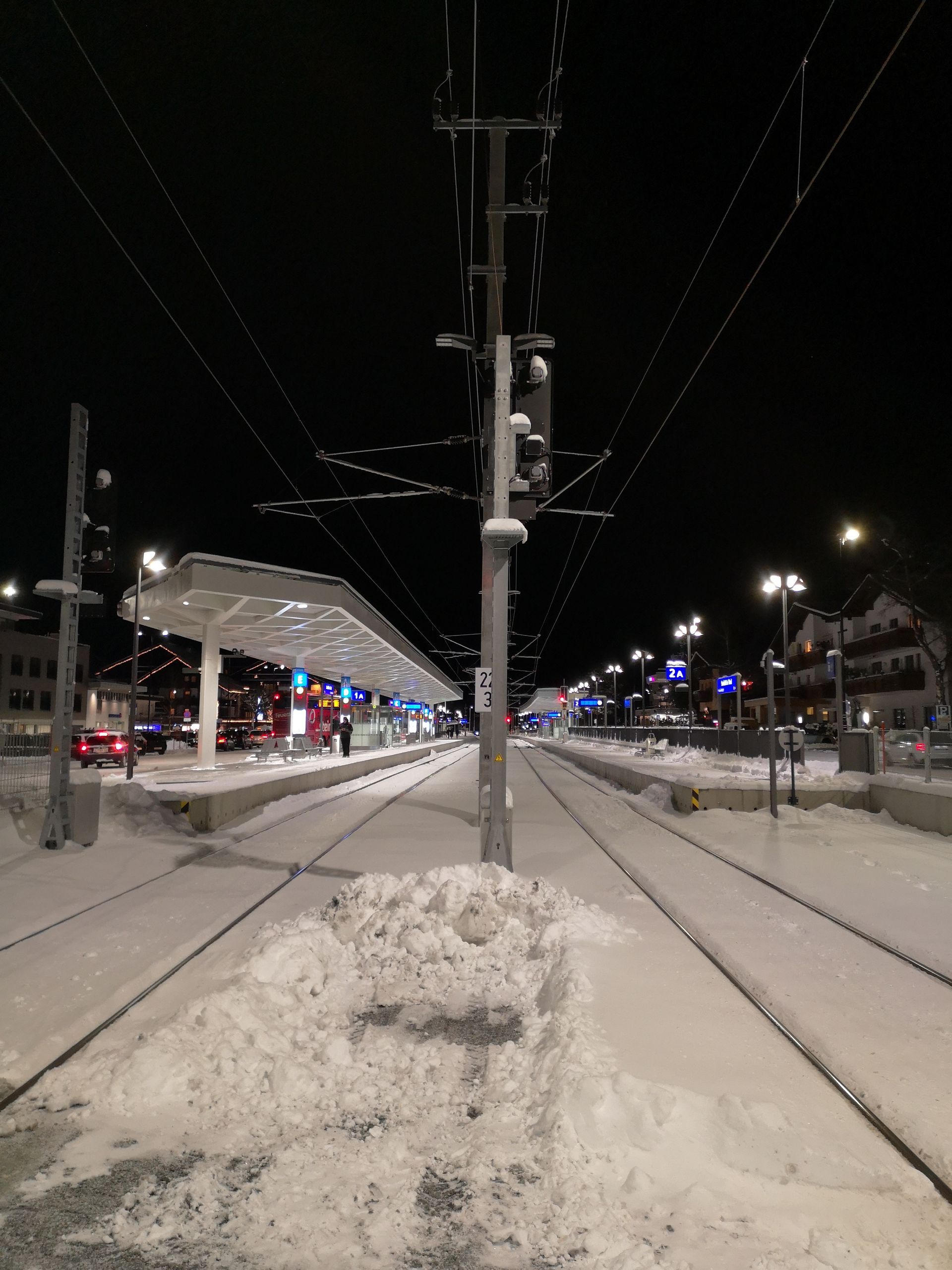 Ein Bahnhof ist nachts mit Schnee bedeckt.