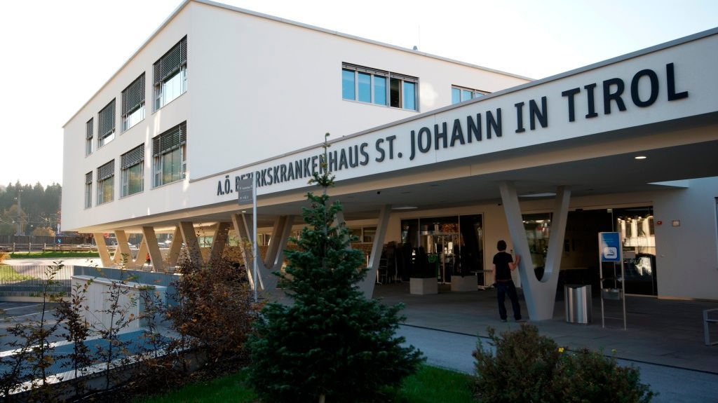 Ein großes weißes Gebäude mit einem Schild mit der Aufschrift St. Johann in Tirol