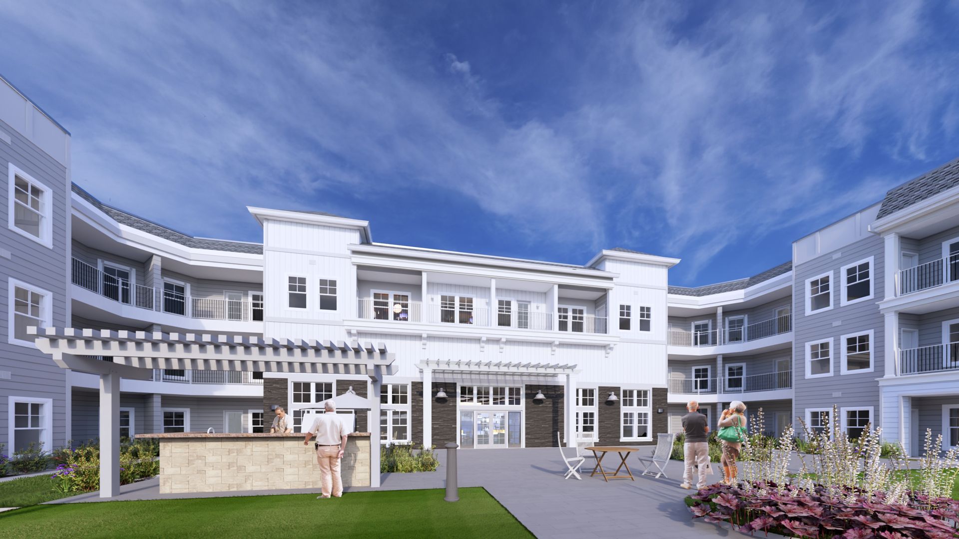 Courtyard of a modern gray-and-white apartment complex with balconies, lawn, and a few people standing outside