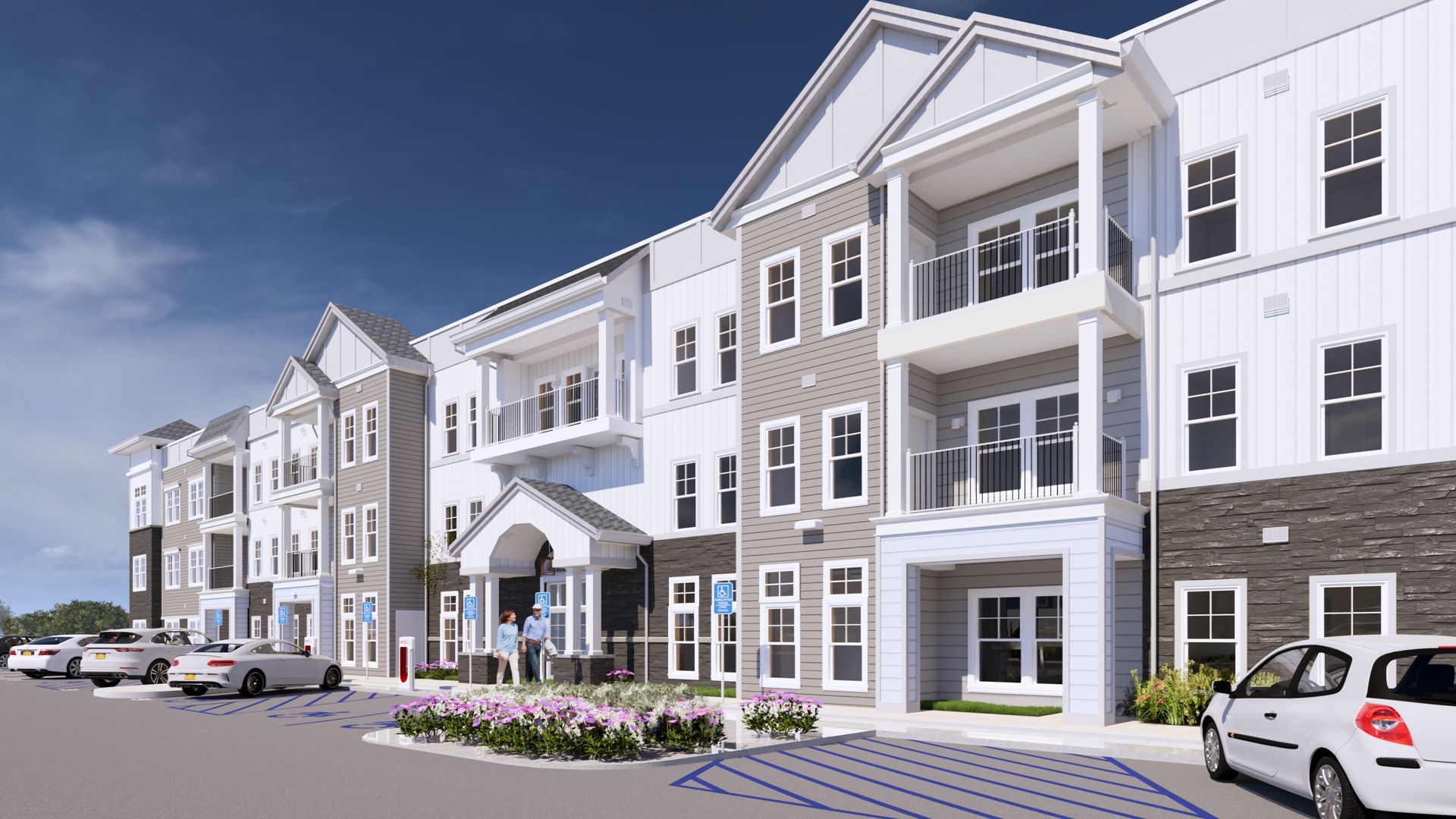 Modern apartment complex with balconies, white and gray siding, parked cars, and a landscaped entrance