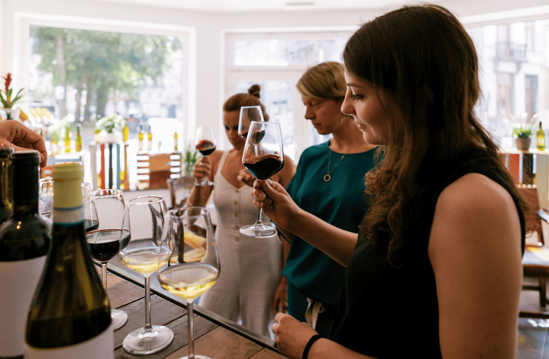 A group of women are sitting at a table drinking wine.