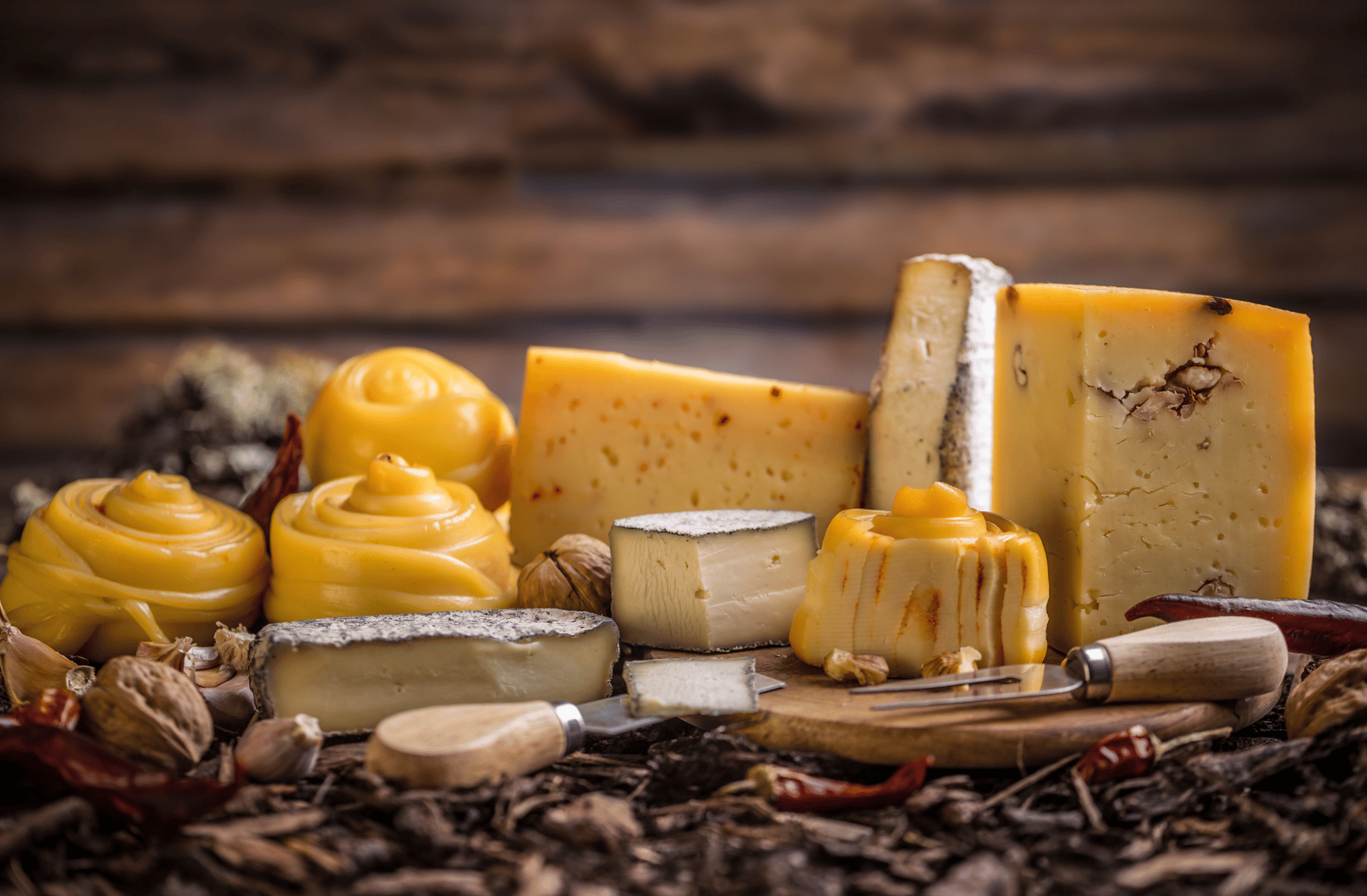 There are many different types of cheese on the table.