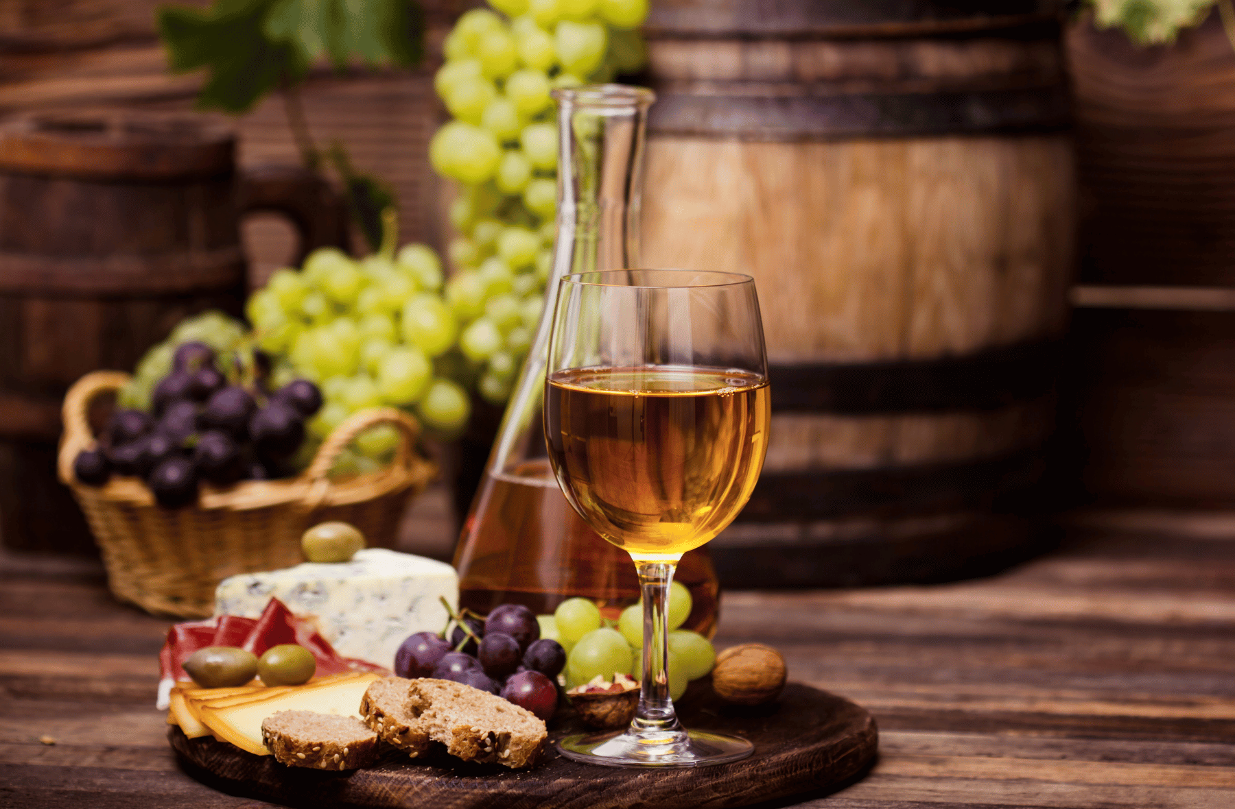 A glass of wine and a bottle of wine are on a wooden table.